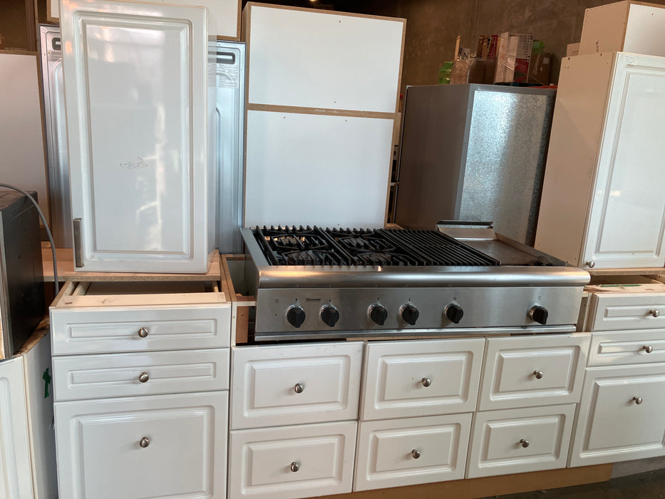 Kitchen with white cabinets, stainless steel stove, and silver handles.