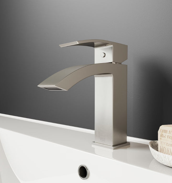 Modern silver faucet on a bathroom sink with a gray wall background