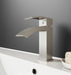 Modern silver faucet on a bathroom sink with a gray wall background