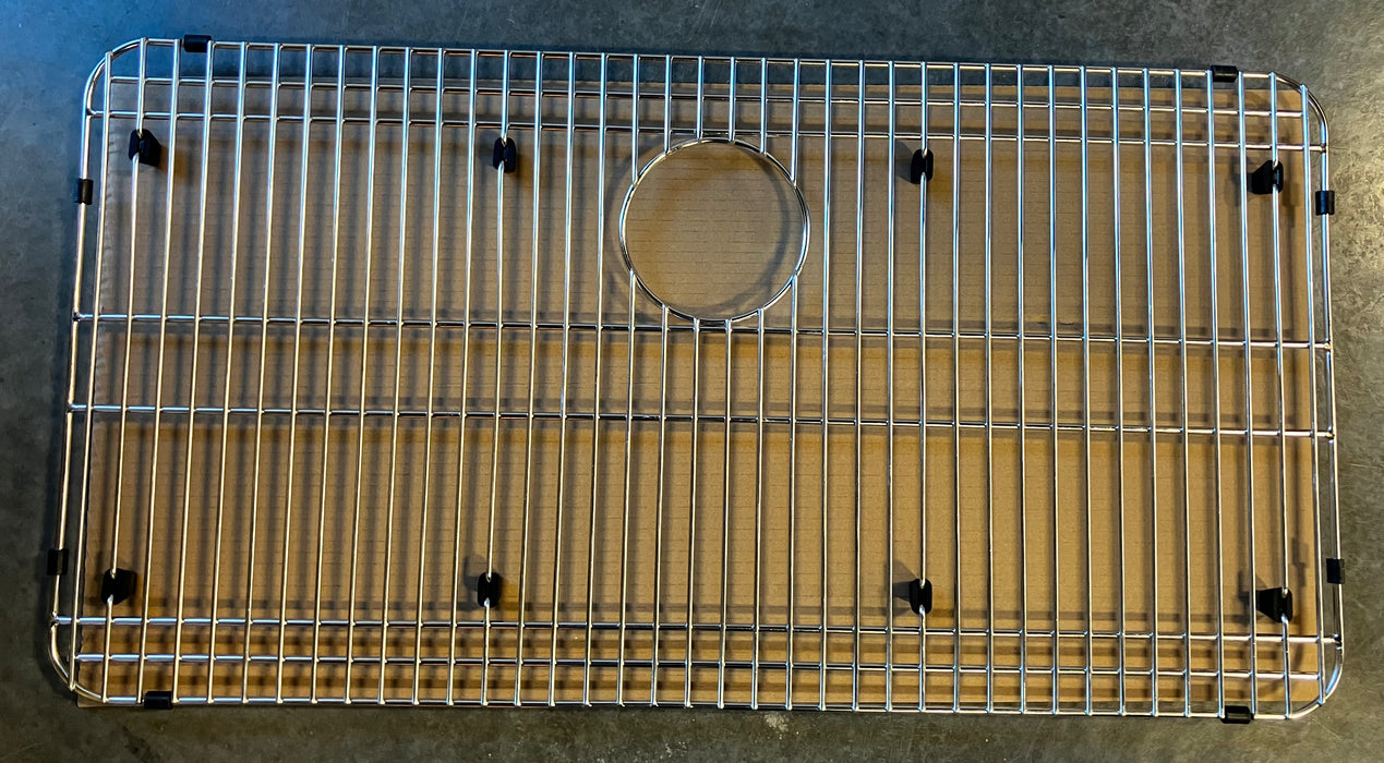 Metal kitchen sink grid on a gray surface